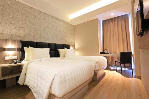 Ένα ή περισσότερα κρεβάτια σε δωμάτιο στο Luminor Hotel Jambi Kebun Jeruk By WH