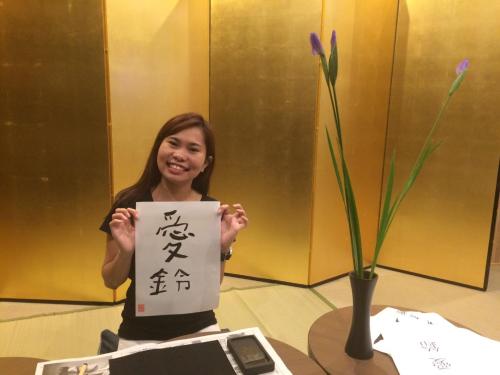 a woman holding up a piece of paper with a plant at Tokyo Guest House Itabashi-juku in Tokyo