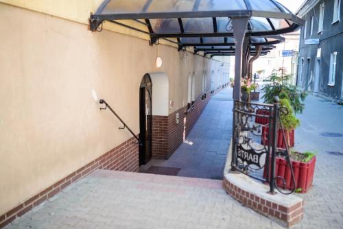 an entrance to a building with an umbrella at Hotel Bartis in Bartoszyce