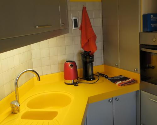 una cocina amarilla con fregadero y un aparato rojo en Apartment Veseli en Split