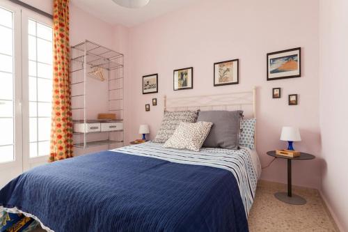 1 dormitorio con 1 cama con edredón azul en Apartamento Jardin de Santa Paula en Sevilla