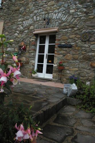 a stone building with a window and flowers in front of it at Locanda di Campagna in Mulazzo