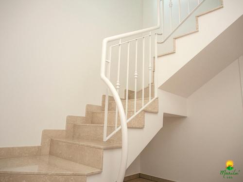 a white staircase with white railings in a house at Marilù B&B in Matino