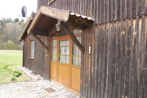a wooden barn with a large door and windows at Pałac Wojciechy in Wojciechy
