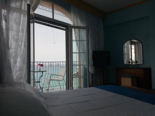 a bedroom with a bed and a view of a balcony at Madalenas B&B in Pelekas