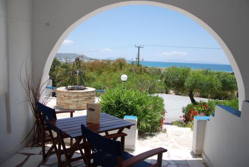 a patio with an archway and a table and chairs at Koulas Pension - Red Lake in Agios Prokopios