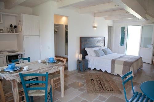 una camera con letto, tavolo e sedie di Agrumare Farm Holiday a Marina di Pisticci