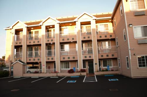 an apartment building with balconies and a parking lot at Howard Johnson by Wyndham Salinas in Salinas