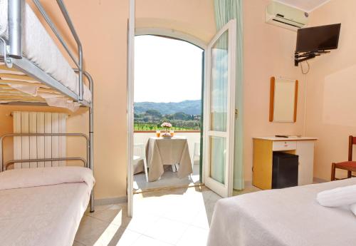 a bedroom with two bunk beds and a balcony at Hotel Costa d'Oro in Santa Maria di Castellabate