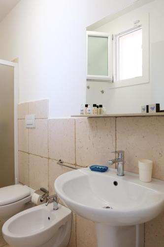 a bathroom with a white sink and a toilet at La Dimora Salento in Carovigno