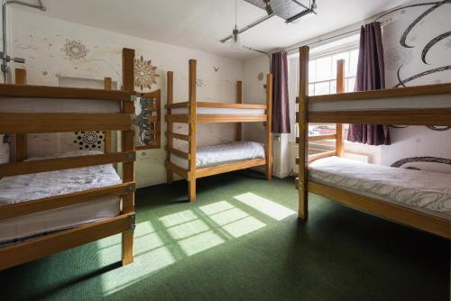a room with three bunk beds and a window at The Full Moon Backpackers in Bristol