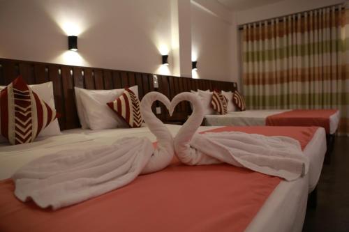 two swans made out of towels on two beds at Cozy Sea view Inn in Hikkaduwa