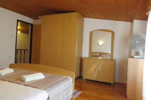 sypialnia z łóżkiem, komodą i lustrem w obiekcie Terrace apartment Beba - Pag w mieście Pag