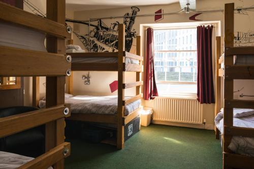 a room with three bunk beds and a window at The Full Moon Backpackers in Bristol