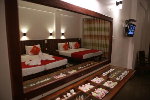 a hotel room with two beds and a mirror at Cozy Sea view Inn in Hikkaduwa