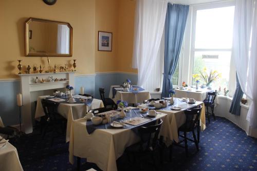 a dining room with tables and a mirror and a window at Leamington House in Barmouth