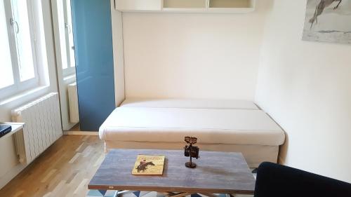 メゾン・ラフィットにあるMagnifique studio coeur Maison-Laffitteのベッドとテーブル付きの小さな部屋