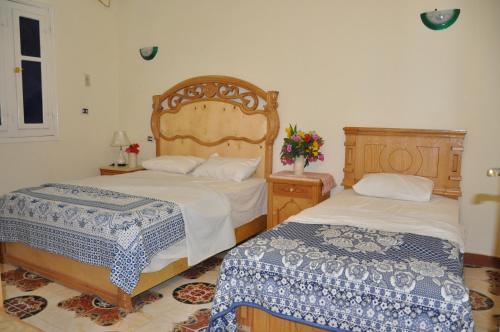 a bedroom with two beds and a dresser at Villa Omar EL Sharif in Luxor