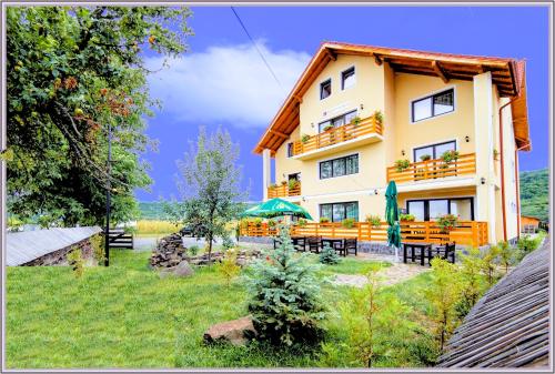 a building with tables and chairs in front of it at Camves Inn in Sighetu Marmaţiei