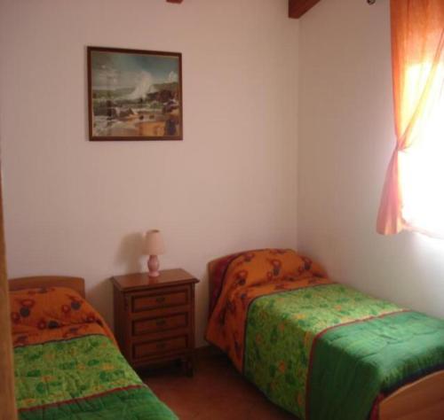 - une chambre avec 2 lits, une table et une photo dans l'établissement Casa Stella, à Alghero