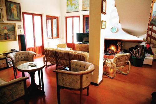 ペダーゾにあるVilla del Paralleloのリビングルーム(椅子、テーブル、暖炉付)
