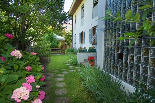 a garden with pink flowers next to a building at Haus Piger in Termeno