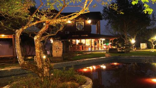 a house with a pond in front of it at night at Moon River Villa in Puli