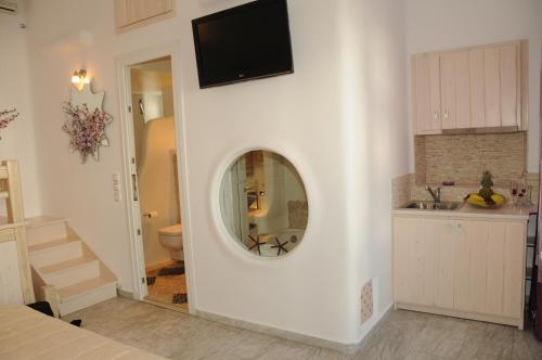 a bathroom with a round mirror on a wall at Starlight Luxury Studios in Mikonos
