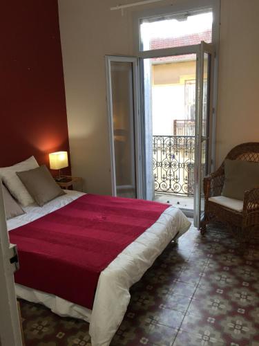 une chambre avec un grand lit et un balcon dans l'établissement Appartement Hippolyte, à Montpellier