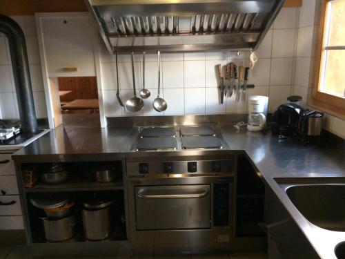 a kitchen with a stainless steel stove top oven at Gruppenhaus im Walliser Alpstyle in Rosswald