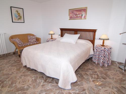 Un dormitorio con una cama grande y una silla. en Villa López, en Santanyí