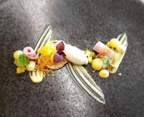 a piece of food on a fork with fruit and vegetables at Romantik Alpenhotel Waxenstein in Grainau