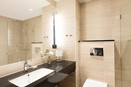 a bathroom with a sink and a mirror at Elite Hotel Academia in Uppsala