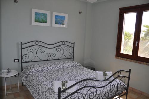 una camera da letto con un letto e una finestra di Casa vacanza Nocellara a Menfi