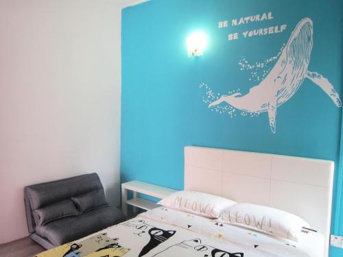 ein Schlafzimmer mit einem Bett und einer blauen Wand in der Unterkunft MILU Homestay - Kuala Selangor in Kuala Selangor
