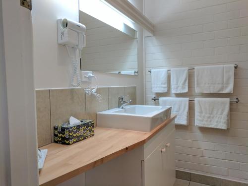 a bathroom with a sink and a mirror and towels at Lake Bolac Motel in Lake Bolac