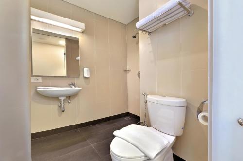 La salle de bains est pourvue de toilettes et d'un lavabo. dans l'établissement Whiz Prime Hotel Sudirman Cilacap, à Cilacap