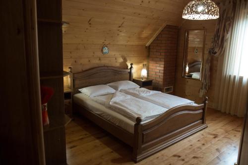 タターリウにあるMagnoliaの木製の部屋にベッド1台が備わるベッドルーム1室があります。