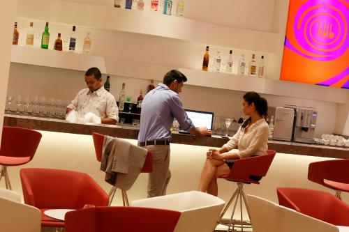 three people standing at a bar in a restaurant at ibis Coimbatore City Centre - An Accor Brand in Coimbatore