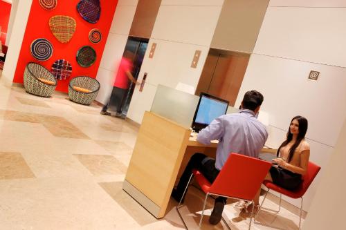 a man and a woman sitting at a desk with a computer at ibis Coimbatore City Centre - An Accor Brand in Coimbatore