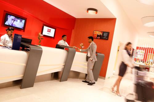 a group of people standing at a counter in a restaurant at ibis Coimbatore City Centre - An Accor Brand in Coimbatore