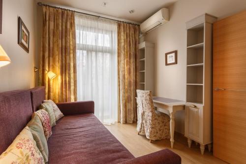 モスクワにあるFortEstate Leninskiy prospekt 72/2のソファ、デスク、窓が備わる客室です。