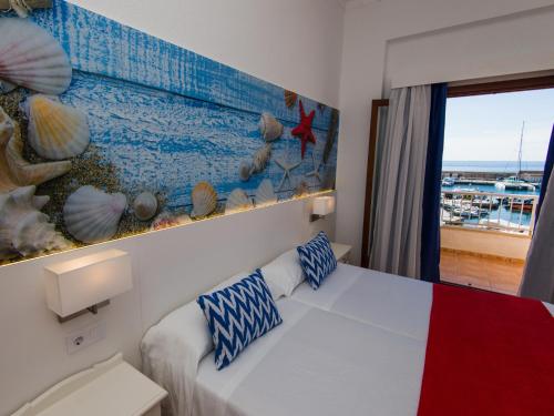 sypialnia z łóżkiem i obrazem na ścianie w obiekcie Hostal Cala Ratjada w Cala Ratjada
