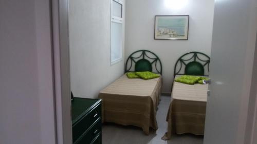 Villaggio AzzurroにあるL'Ancora Azzurraのベッド2台(緑の枕付)が備わる客室です。