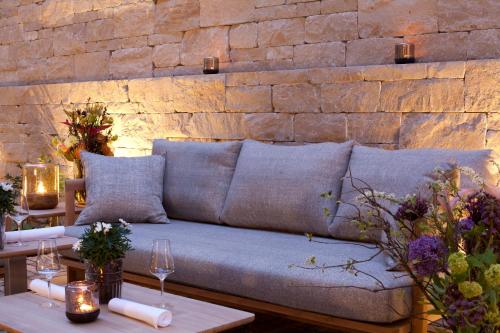 a couch in a room with a brick wall at Gasthof Zufriedenheit in Naumburg