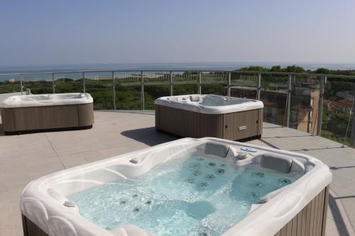a jacuzzi tub on a patio with the ocean at Eraclea Palace Hotel 4 stelle S in Eraclea Mare
