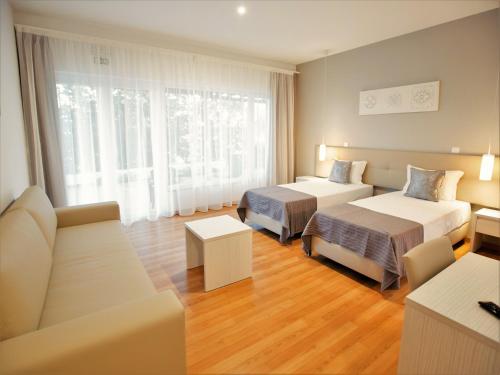 pokój hotelowy z 2 łóżkami i kanapą w obiekcie Tavira Monte w mieście Tavira