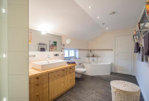 een badkamer met een wastafel, een bad en een toilet bij Villa Scandic Apartments in Rust