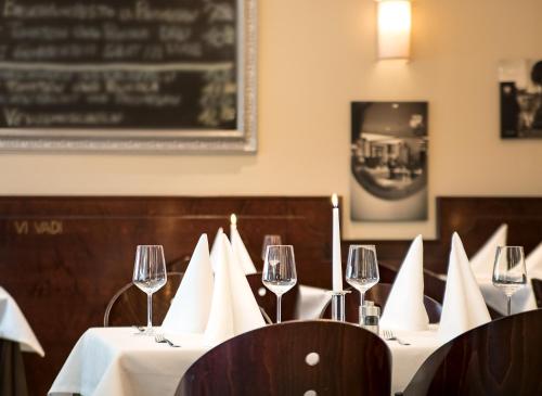 a dining room with a table with wine glasses at Downtown Vi Vadi Hotel in Munich