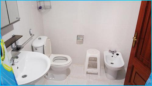 een witte badkamer met een toilet en een bidet bij Apartamento Paseo del Puerto 2 in Finisterre